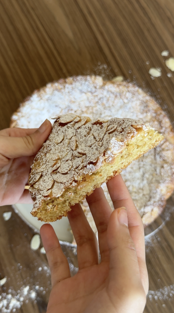 gluten free almond cake slice with powdered sugar and almond topping